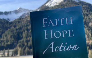 A picture of Diana's book, Faith, Hope, Action, with a mountain landscpe in the background.